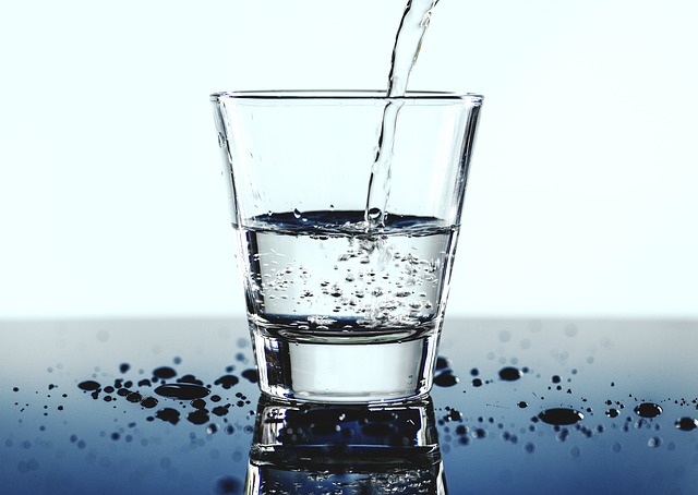 decorativa, un vaso de agua en post sobre medicina ambiental para sugerir que ingerimos tóxicos con la comida y bebida